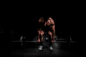 Adults perform controlled resistance exercises in a bright home workout space with dumbbells and a training journal.