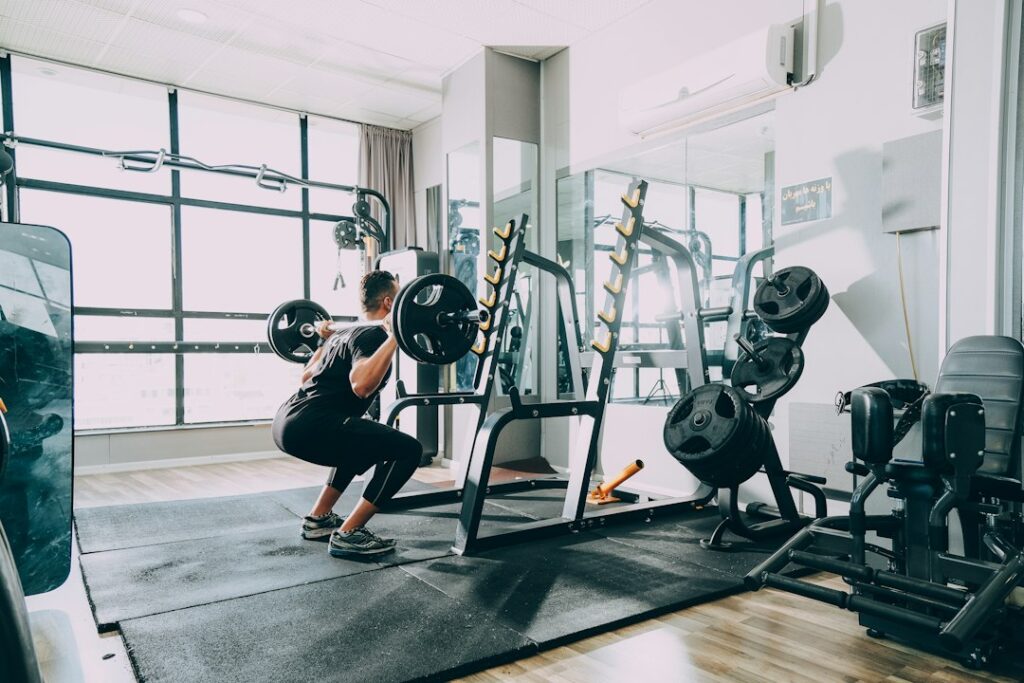 Person performing controlled bodyweight exercises on a mat in a bright home workout space.
