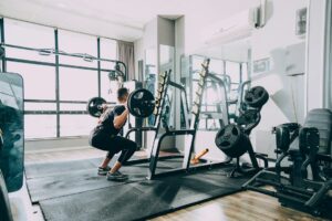 Person performing controlled bodyweight exercises on a mat in a bright home workout space.